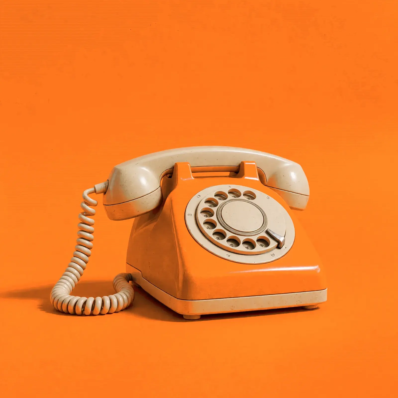 Oranges Wählscheibentelefon mit Spiralkabel